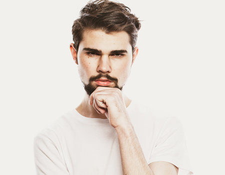 Young thinking man over white backgroundの写真素材