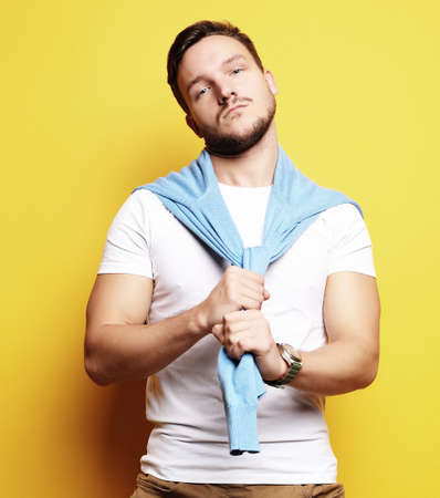 young man in smart casual wear looking at camera over yellow bacの写真素材