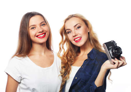 Pretty girls friends holding a vintage camera