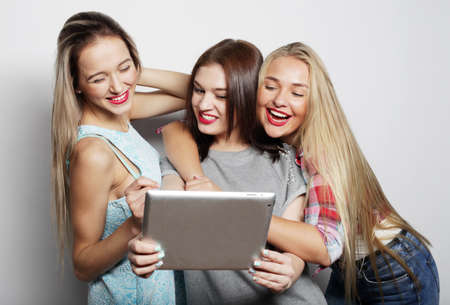 three smiling teenage girls with tablet pc computers