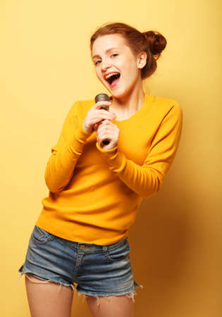 Funny young redhead girl in yellow sweater posingの写真素材