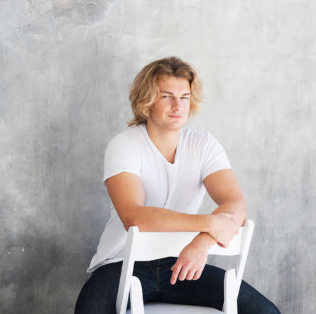 stylish fashion man model sitting on the chairの写真素材