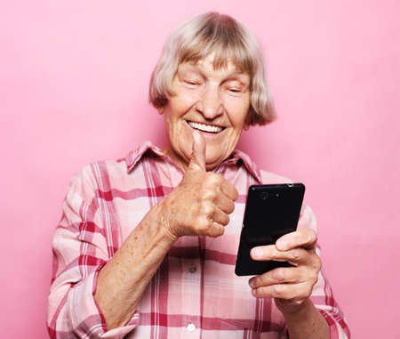 Photo of crazy ecstatic old woman use smartphone