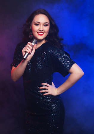 Beauty model girl singer with a microphoneの写真素材