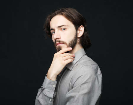 unhappy man touching his forehead over black background