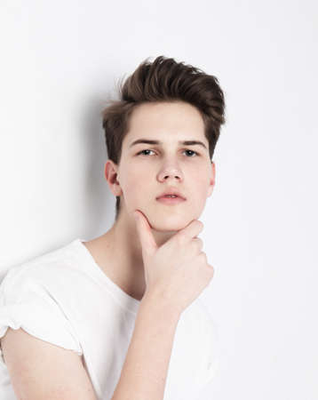 High Fashion model man portrait isolated on gray background. Handsome guy closeup. Stylish haircut,...
