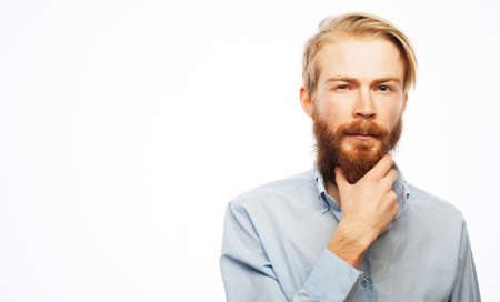 Serious thoughtful male with ginger beard, dressed casually isolated over white background. Pensive...