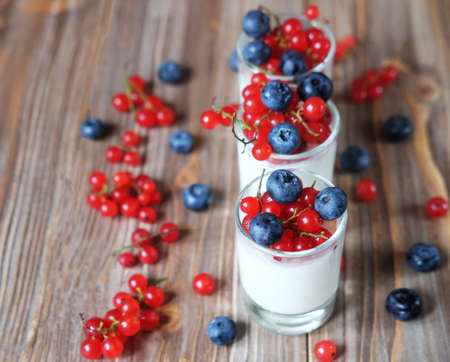 Healthy eating, food and diet concept. Yogurt with fresh berries in glass jar, on wooden backgroundの写真素材