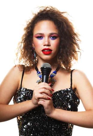 Fashion, party and people concept: Beautiful african woman holding a microphone and preparing to sing a songの写真素材