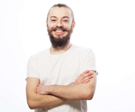 Lifestyle and people concept: Bearded young man wearing white t-shirt with his arms crossed over...
