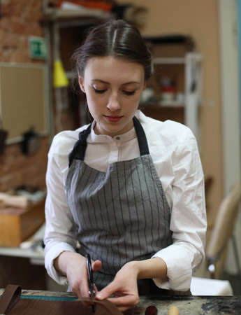 Lifestyle, freelance and home business concept: young woman works in a bag making studio