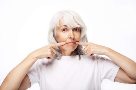 Grandmother with funny expressions isoltaed on white background. Lifestyle and old people concept.の写真素材