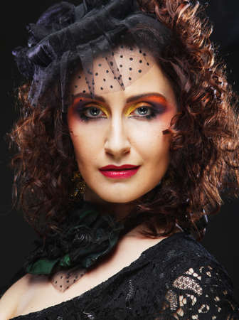 Elegant middle-aged woman in a black hat with a veil and a luxury dress. Vintage style.