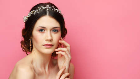 Portrait of the young bride with diadem on pink backgroundの写真素材