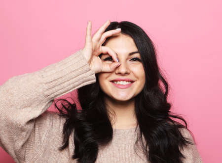lifestyle, emotion and people concept: young brunette woman smiling happy doing ok sign with hand on...
