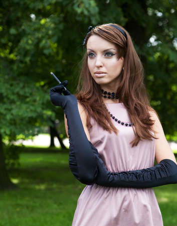 Beautiful elegant young lady enjoying a day in the park. vintage style.の写真素材