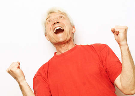 Senior man standing over isolated white background very happy and excited doing winner gesture with arms raisedの写真素材