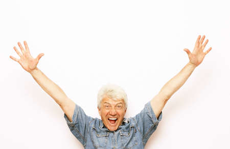 Senior grey-haired man wearing casual clothes very happy and excited doing winner gesture with arms...