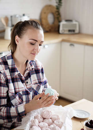Beautiful woman pastry chef makes sweet cakes in kitchen.の写真素材