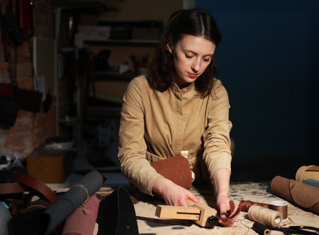 Lifestyle, freelance and home business concept: young brunette woman works in a bag making studio