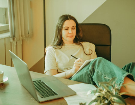 Woman on remote work or online education, using tablet computer, papers and notes, indoors at office...