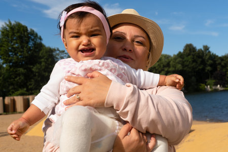 Little girl toddler with her mother on the beach. Time for play. happy summer.の写真素材