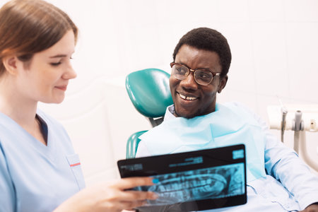 People, medicine, stomatology, technology and health care concept. Female dentist showing teeth...