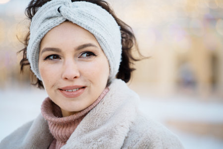Portrait of a young woman in a fur coat on a winter day, close up