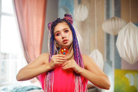 Gorgeous young woman with dreadlocks hairstyle wearing pink dress, doll style, bright make, up in the pink room.の写真素材