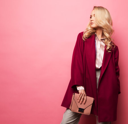 Fashion, people and lifestyle concept: Beautiful woman long blond curly hair wear cashmere coat and holding handbag.の写真素材
