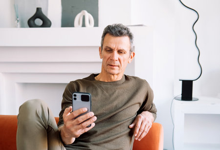 technology, people, lifestyle and communication concept - happy senior man dialing phone number and...
