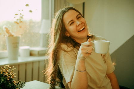 Young businesswoman sitting on the desk with cup of coffeeの写真素材