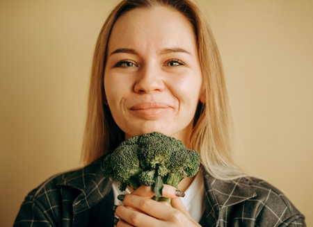 smiling woman with long hair healthy lifestyle portrait with green broccoli.の写真素材