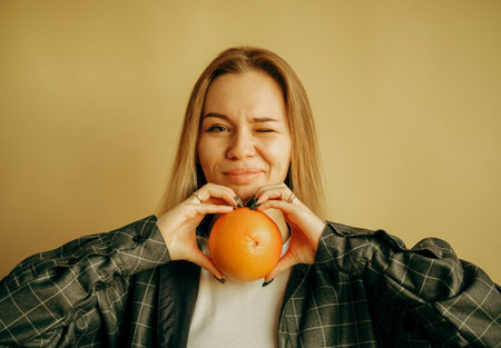 Inspired happy millennial woman show orange. Sports, weight loss and body care, choice of harmful and healthy foodの写真素材