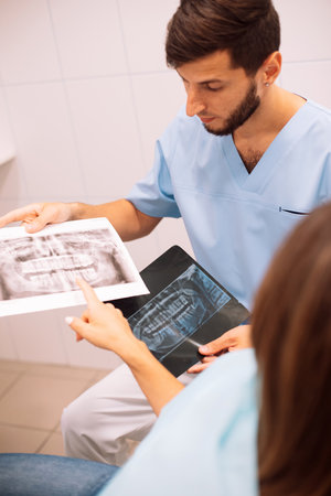 Dentist shows an X-ray of jaw with an implanted tooth. Dentist services concept
