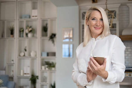 Happy middle aged mature woman enjoying using mobile apps texting typing messages, smiling old adult...