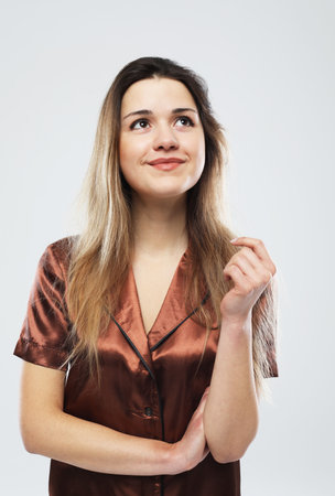 Lifestyle, fashion and people concept: beautiful young female with long hair dressed in brown pajamaの写真素材