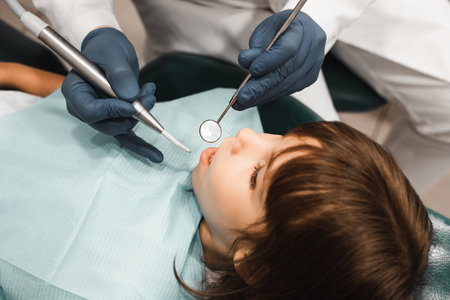 People, medicine, dentistry, technology and health care concept. Male dentist working with little girl in clinic.の写真素材