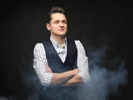 Portrait of handsome stylish man in elegant black suit over dark backgroundの写真素材