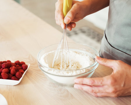 Close up Woman Hand Mixed Batter on Clear Bowl with Baloon Whisk Step by Step Baking Preparation in...