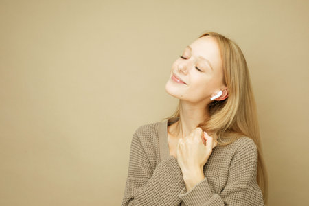 lifestyle, emotion and young people concept: young woman wearing brown sweater posing over beige color backgroundの写真素材