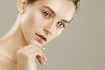 Beauty Woman face Portrait. Beautiful Spa model Female with Perfect Fresh Clean Skin. Portrait over gray background.の写真素材
