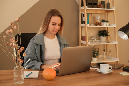 Young blond woman dressed casual working laptop. Business woman busy working on laptop computer at office.の写真素材