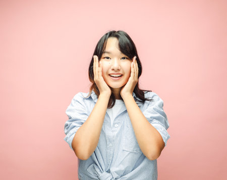 Cheerful Young Asian woman amaze with shock deal, isolated on pink background. Lifestyle and people concept.の写真素材