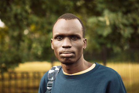 A young black man is walking in the park. Close up portrait. Summer time.の写真素材