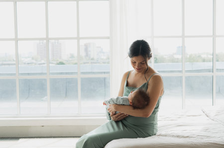 Loving young mom caring of her newborn baby at home.の写真素材