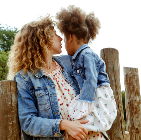 A beautiful young mother plays with her little daughter in a park near the beach. Having fun and feeling happy.の写真素材