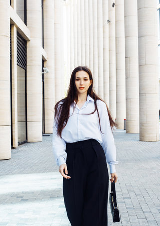 Fashionable woman. Young female model with long hair wears white shirt and black paints. Summer day.の写真素材