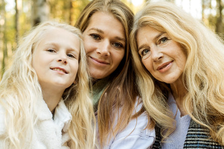 Lifestyle and people concept. Grandmother With Granddaughter And Mother In Autumn Park.の写真素材