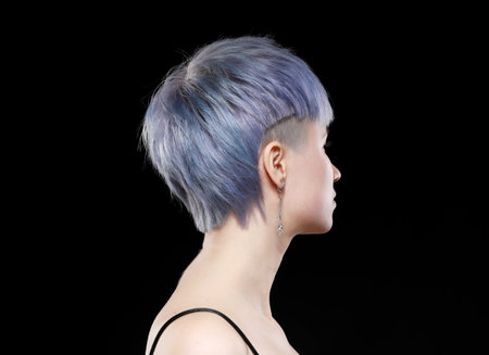Young woman with stylish short haircut and colored hair dyeing - blue-green hair. Close-up portrait, back view.の写真素材